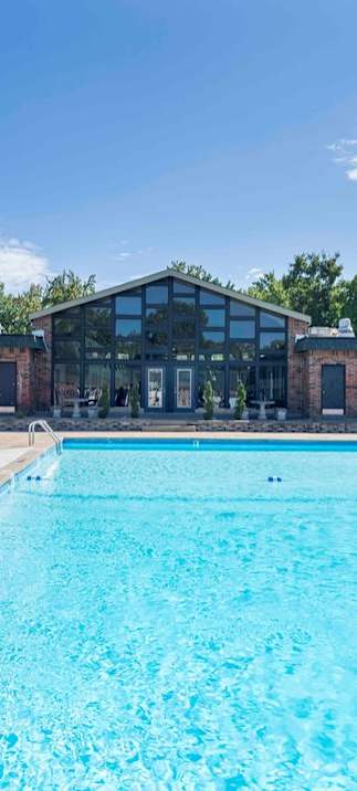 A large outdoor swimming pool surrounded by a black fence.