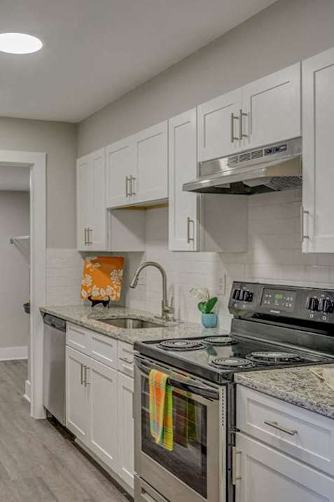 a kitchen with white cabinets and stainless steel appliances