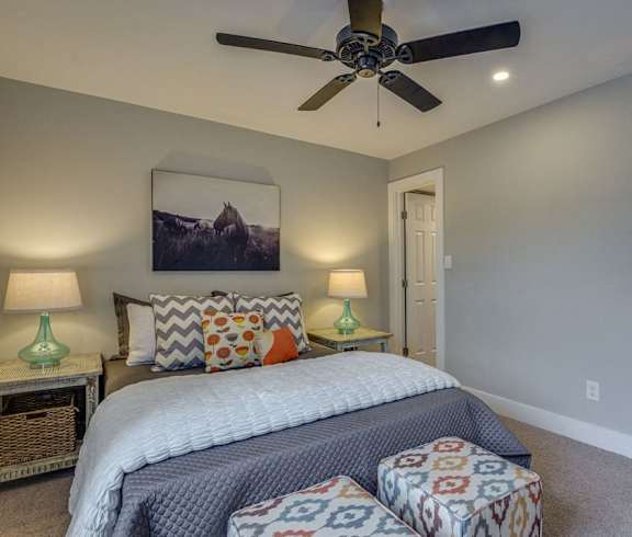 a bedroom with a bed and a ceiling fan