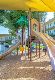 A playground with a yellow canopy and a purple slide. at Citrus Court Apartments, Whittier, CA, 90606