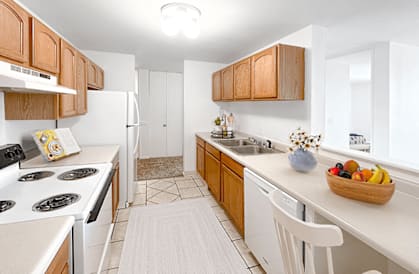 a kitchen with white appliances and wooden cabinets