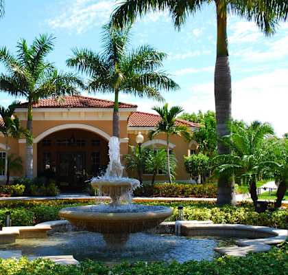 a fountain in front of a building with palm trees at Renaissance, Florida, 33409