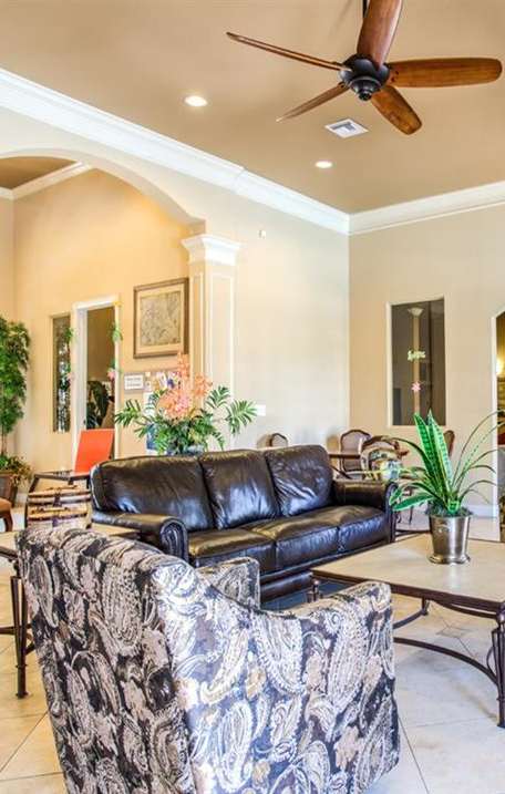 A spacious room with a ceiling fan and wooden flooring.