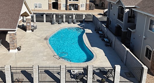 A swimming pool in a backyard surrounded by a fence.