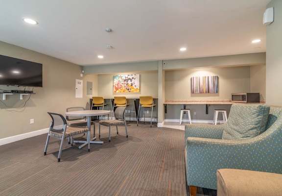a lobby with tables and chairs and a television at Citrus Court Apartments, Whittier, CA