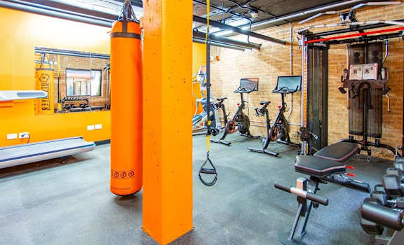 A gym with orange columns and exercise equipment.