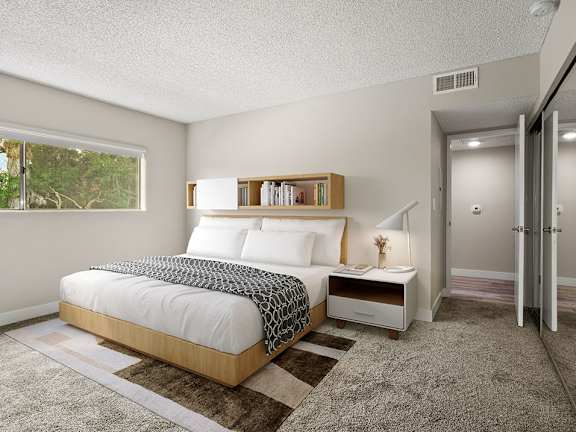 Carpeted bedroom with large window for natural light.