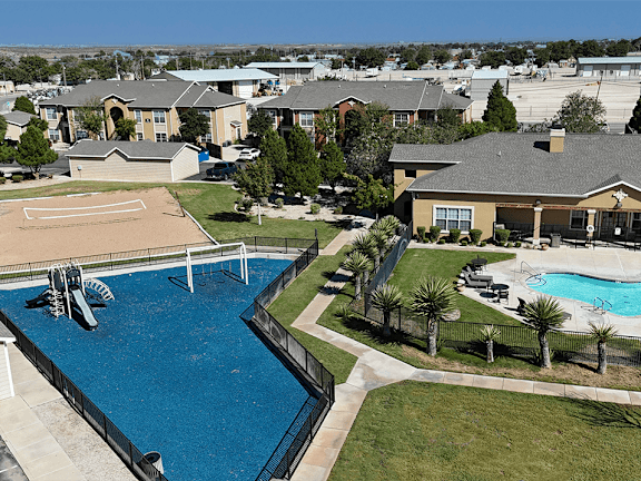 A swimming pool surrounded by a fence and palm trees.