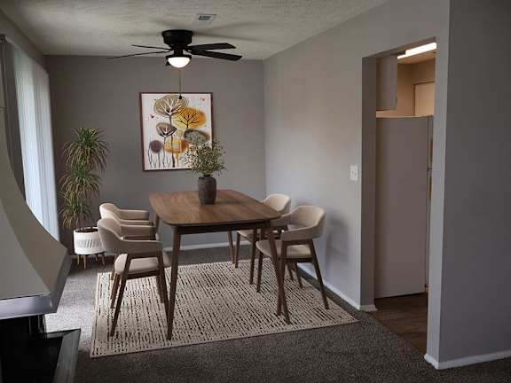 A dining room with a table and chairs.