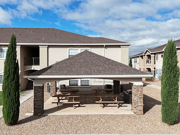 A covered patio area is in front of a two-story house.