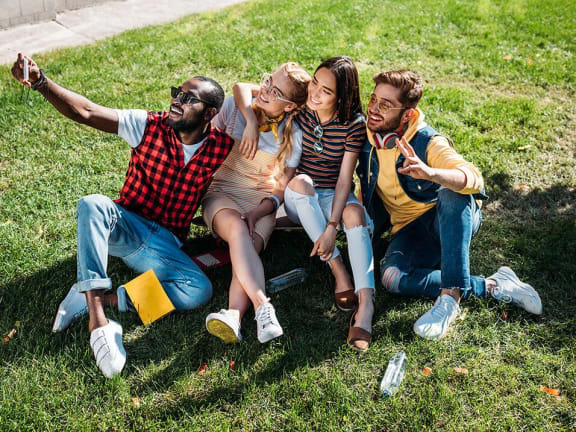 happy group of people sitting on grass
