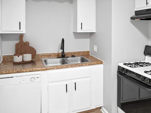 A kitchen with white cabinets and a black stove top.