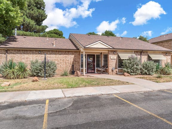 a small brick house with a sidewalk in front of it