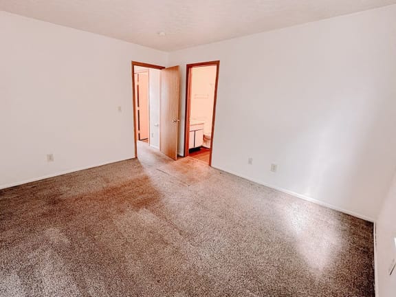 an empty living room with carpet and white walls