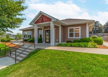 the front of a small house with a porch and a lawn