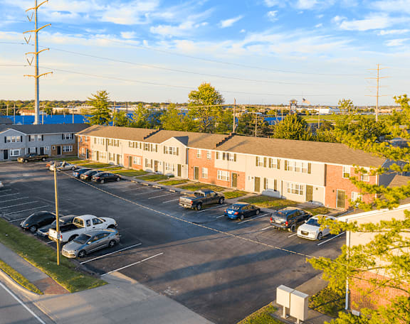 an aerial view of an apartment complex with cars parked in a parking lot