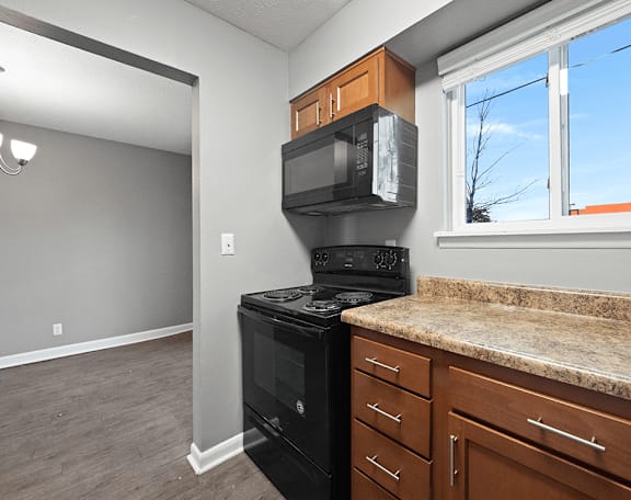 an empty kitchen with a stove and a microwave
