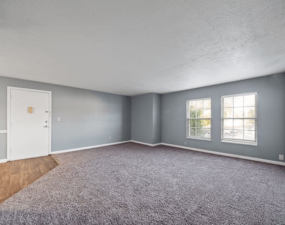 an empty room with gray walls and a white door and window