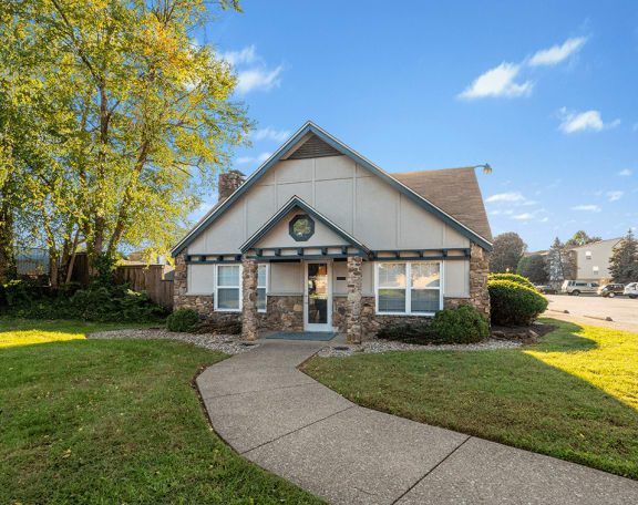 the front of a house with a walkway and grass