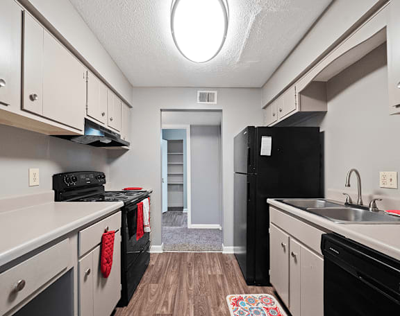 a kitchen with white cabinets and black appliances and a black refrigerator