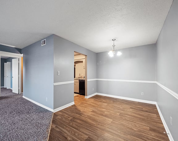 an empty living room with wood flooring and blue walls