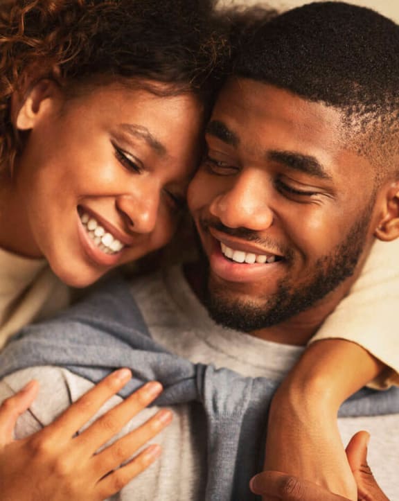 a man and a woman are hugging each other and laughing