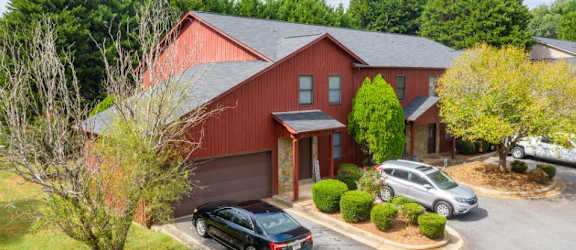 a red house with a black car parked in front of it