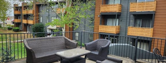our apartments have a patio with chairs and a tableat The Lodge Apartments, Oklahoma