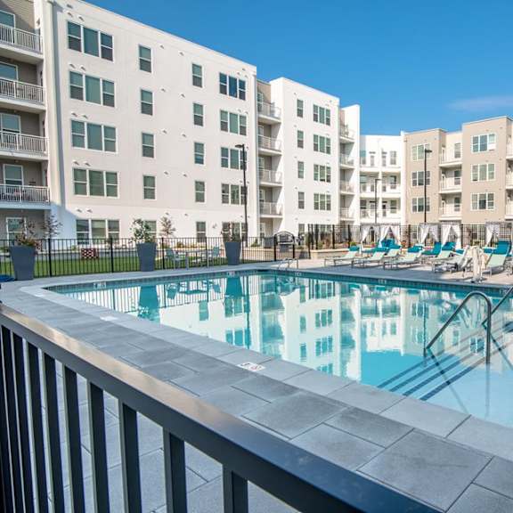 A large swimming pool in front of apartment buildings.