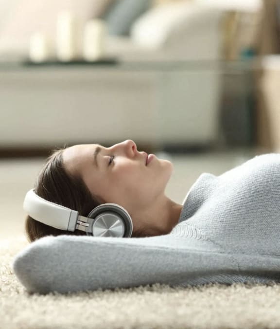 a woman laying on the floor with headphones on