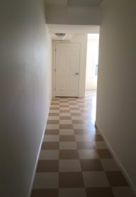 a hallway with a checkered floor and a white door