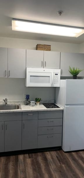 a kitchen with white cabinets and a sink and a refrigerator