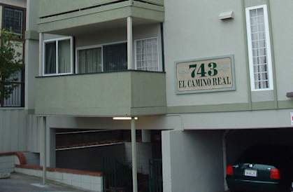 an apartment building with a car parked in front of it