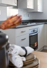 a modern kitchen with grey cabinets and black appliances