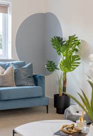 a bedroom with a bed and a nightstand with a lamp and a framed picture