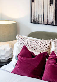 a bedroom with a bed and a nightstand with a lamp and a framed picture
