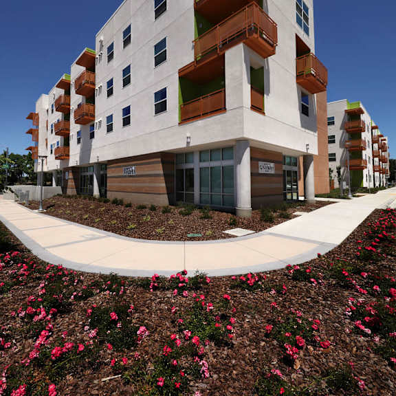A white building with a balcony and a blue sky in the background.