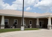 Thumbnail 1 of 4 - A building with a covered walkway and a white pillar.