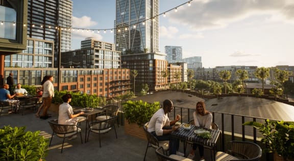 people sitting at tables on a rooftop terrace with cityscape in the background  at La Unión, Tampa, FL, 33605