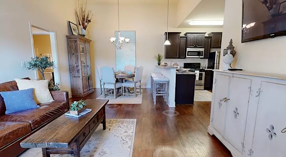 A living room with a brown couch and a wooden coffee table. at The Villas at Nature Walk, Huntsville, Alabama