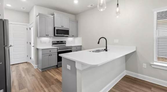 A kitchen with a white countertop and a black refrigerator. at Ovation at Town Madison, Alabama, 35758