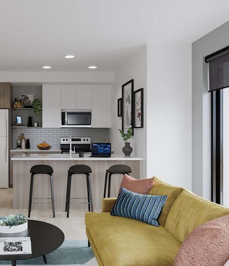 A modern living room with a kitchen area in the background.