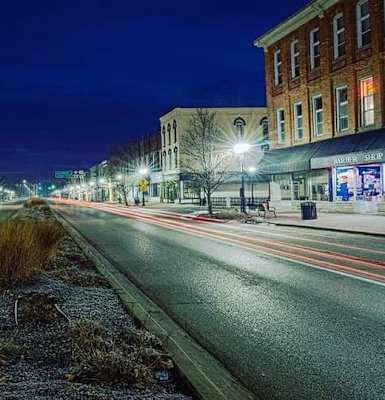 a city street at night with buildings on both sides of the street