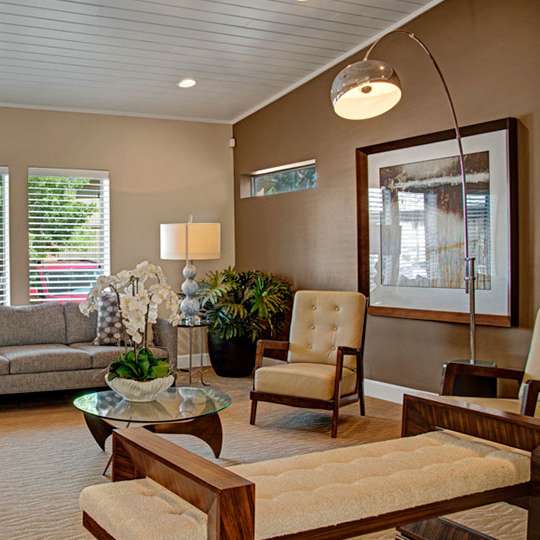 The lounge at the Retreat at Austin Bluffs with two couches, four plush chairs, and a coffee table. 