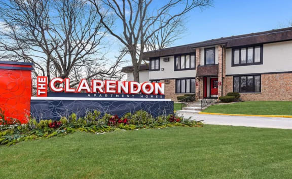 a pathway lined with brick buildings with red doors  at The Clarendon Apartment Homes, Clarendon, IL