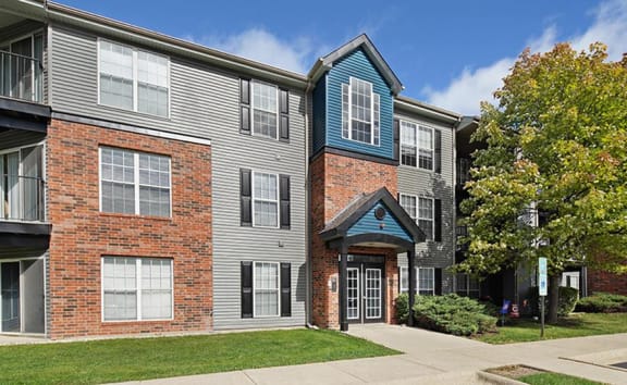 an apartment building with a sidewalk in front of it  at The Mark Apartments, Glendale Heights