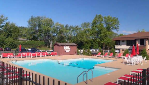 a swimming pool with chairs and tables around it  at The Clarendon Apartment Homes, Clarendon, Illinois