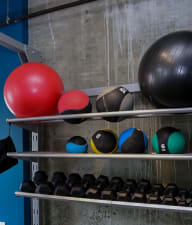 a row of bowling balls on a shelf in a gym