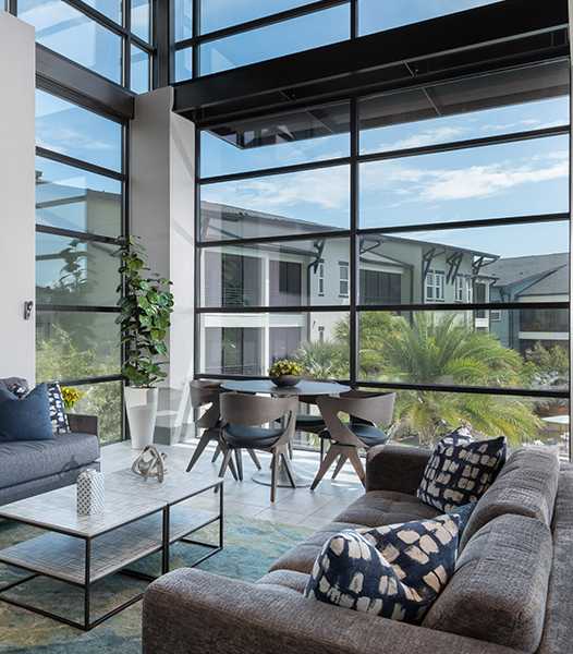 A living room with a grey couch and a flat screen TV mounted on the wall.