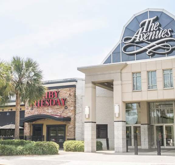 a person with a bag walking down an escalator at AVIA Lofts on Liberty Ridge, Florida, 32256